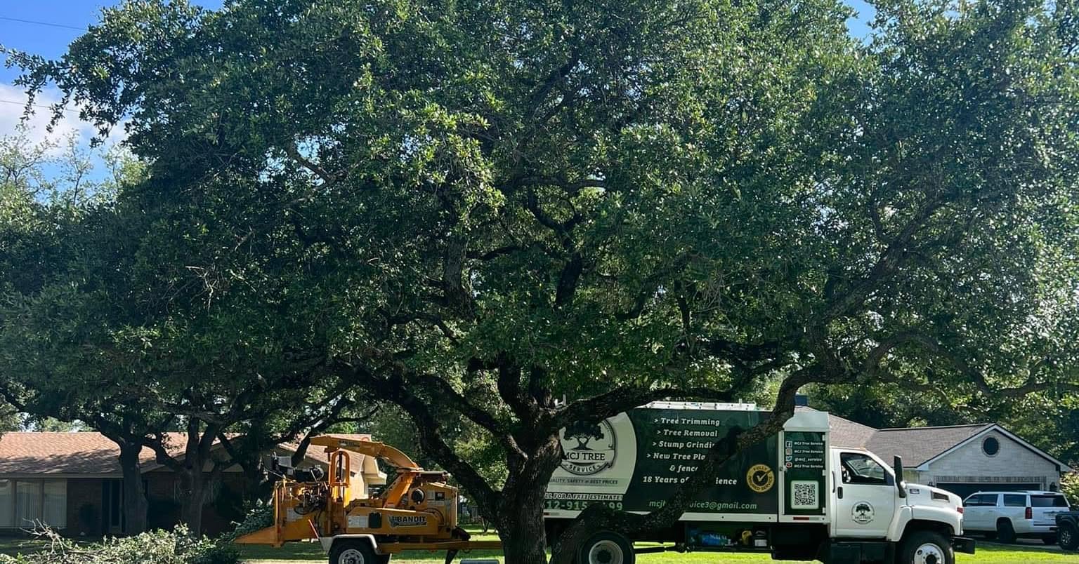 MCJ Tree Service branded truck and wood chipper on a job site